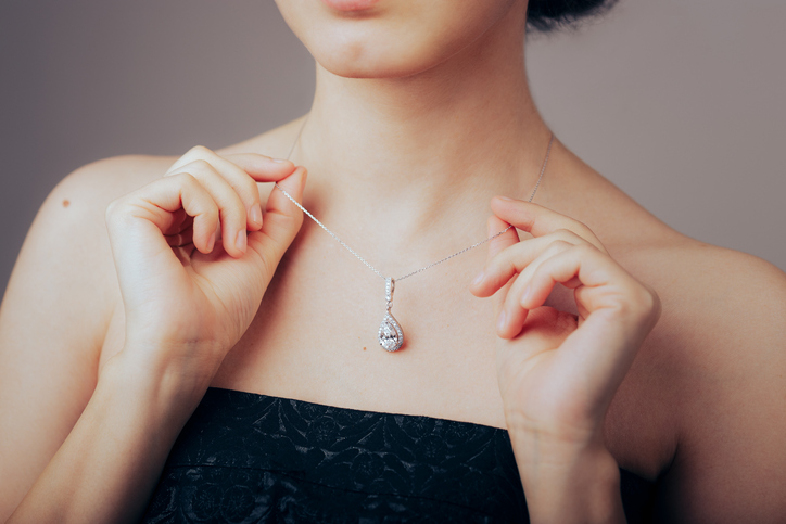 Elegant woman showing off her beautiful and precious fashion piece of jewelry